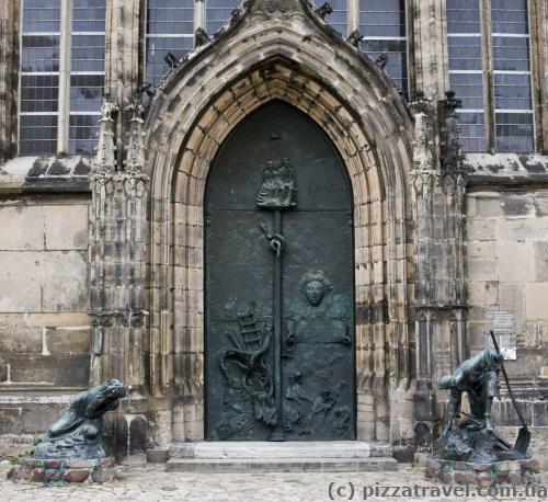 Портал церкви Святого Иоанна. Бронзовая композиция напоминает о разрушении и восстановлении Магдебурга во время и после Второй Мировой Войны.